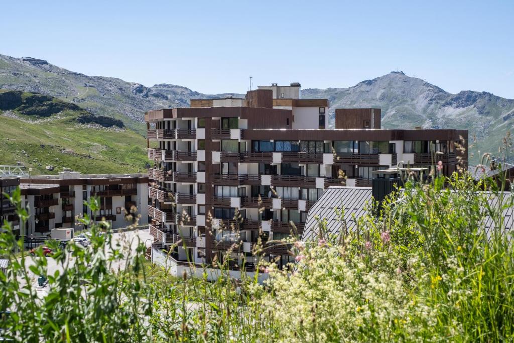 a tall building in the middle of a mountain at Résidence Le Schuss in Val Thorens