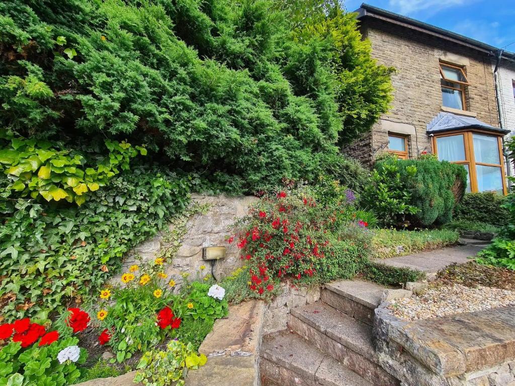a garden with flowers and stairs in front of a house at Character cottage with garden - Central Buxton in Buxton