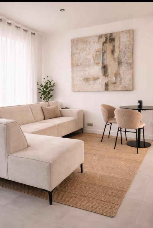 a living room with a couch and a table at Maison prairie en fleurs in Le Perray-en-Yvelines