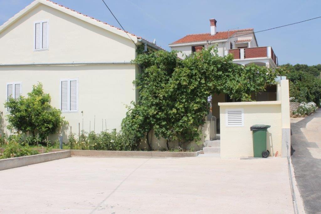 a white house with a driveway next to a building at The Sea House Jaz in Preko