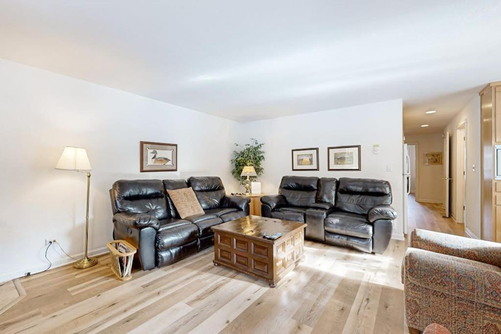 a living room with black leather furniture and a table at Dog-Friendly Sunriver condo with deck bikes in Sunriver