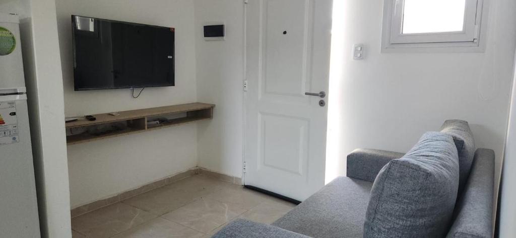 a living room with a couch and a flat screen tv at Añelo Garden Inn in Añelo