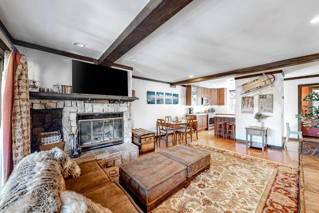 a living room with a fireplace and a tv at Ski getaway with amazing mountain views fireplace pool & river path access in Olympic Valley
