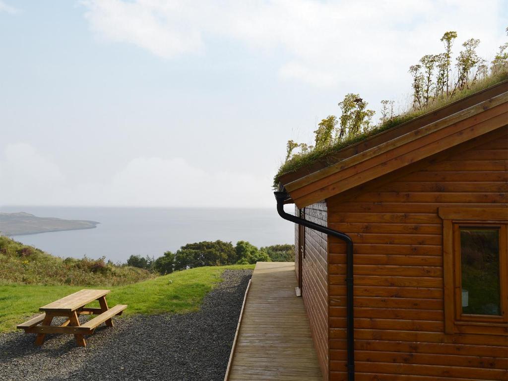 a wooden building with a bench next to it at Seascape in Staffin