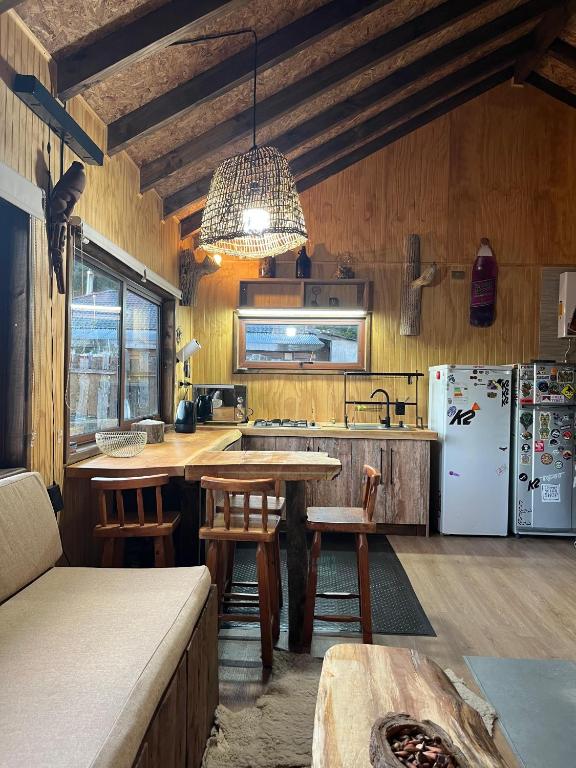 a kitchen with a table and a refrigerator at CasaAndina in Malalcahuello