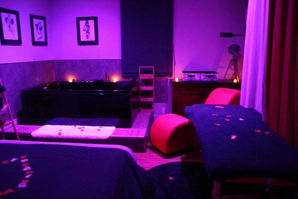a room with two beds and purple lighting at Secret Balnéo in Floirac