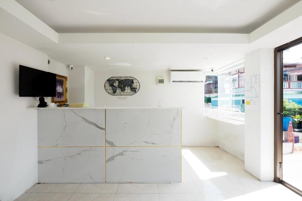 a white room with a marble counter and a tv at Dancenter Rq Suvarnabhumi Airport in Bangkok