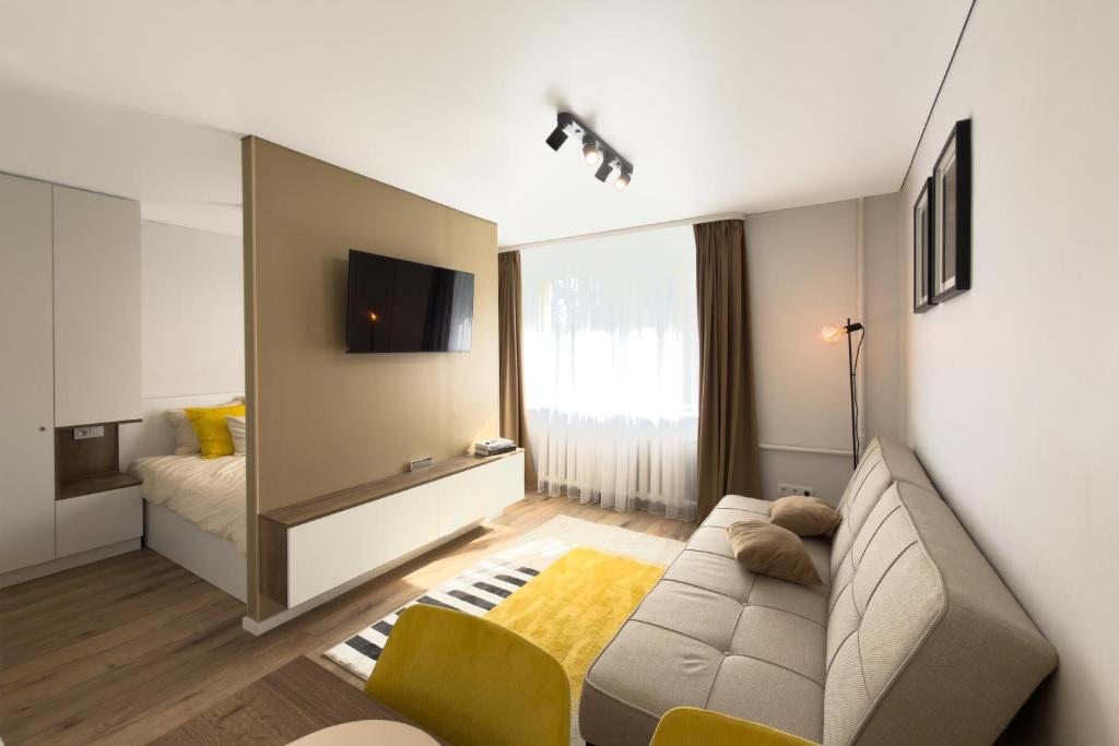 a living room with a couch and a tv at AC Vienibas Square apartments in Daugavpils