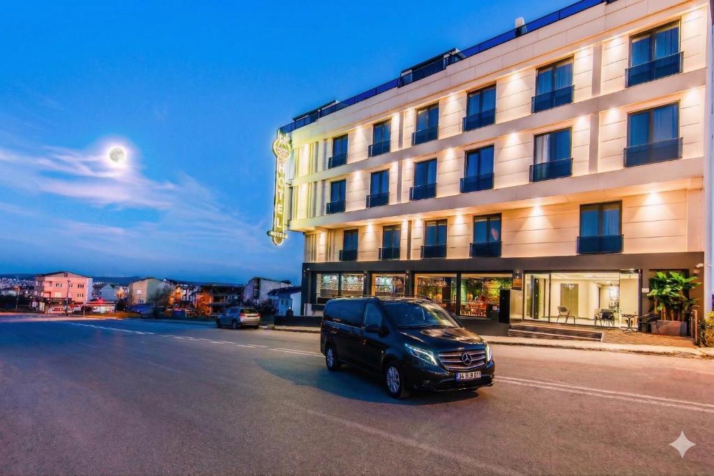 a black van parked in front of a building at Heaven Premium Hotel Restaurant & Airport Shuttle in Arnavutköy