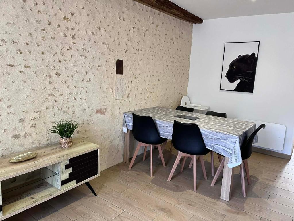 a dining room with a table and chairs at La p'tite maison in Courgains