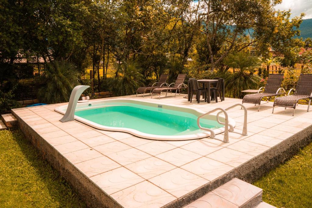 a swimming pool with a hot tub in a yard at Cabanas Malacara in Praia Grande