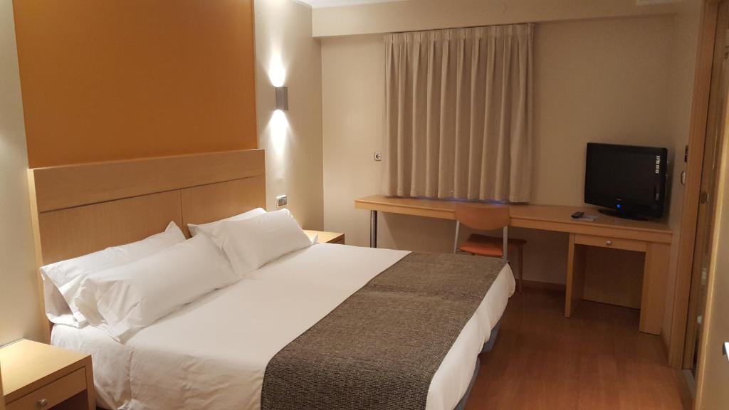 a hotel room with two beds and a television at Espel in Andorra la Vella