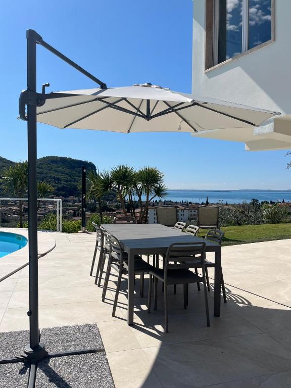 a table and chairs under an umbrella next to a pool at Casa Luca in Garda