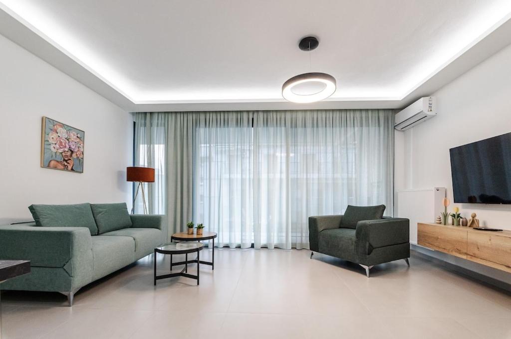 a living room with a couch and two chairs and a television at KAPA Luxury Living in Volos