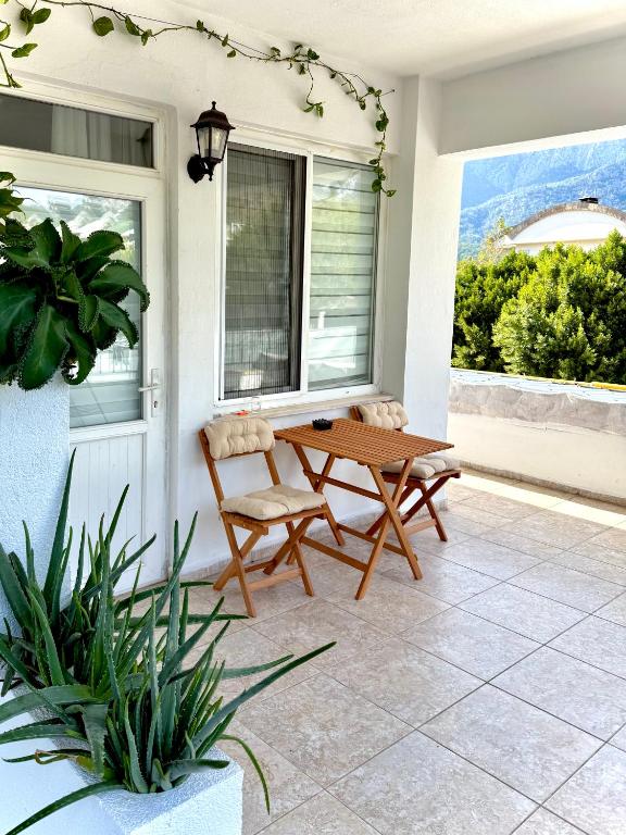 a patio with a wooden table and a chair at Eda Sultan Guesthouse - 5 Min Walk to Göynük Beach in Kemer