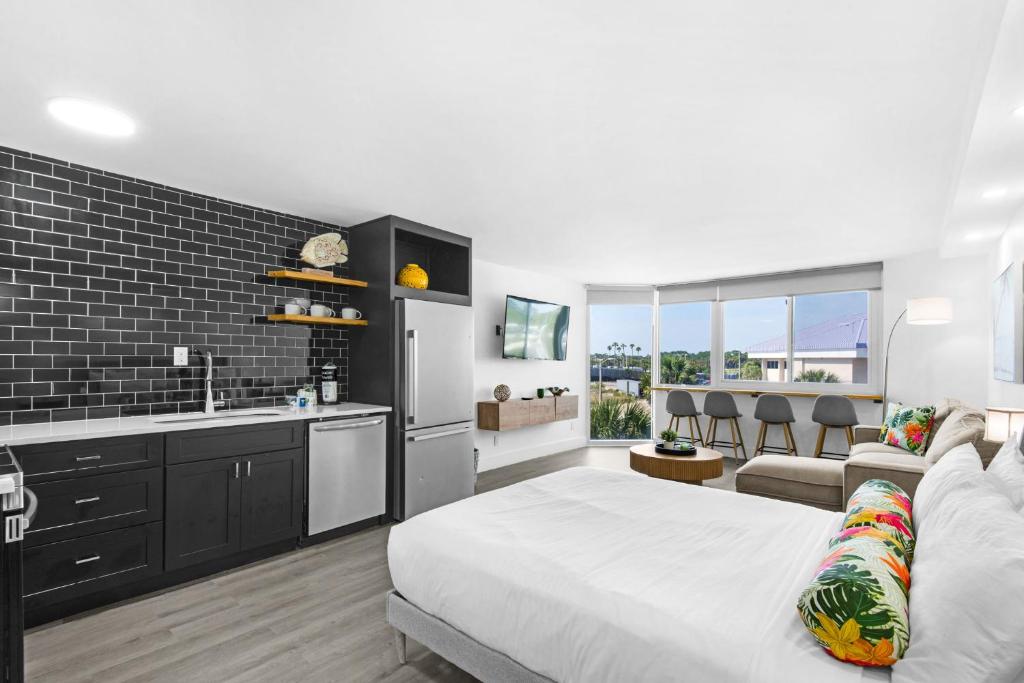 a bedroom with a bed and a kitchen and a living room at Renovated Beach Front Condo TOG 310 in Panama City Beach
