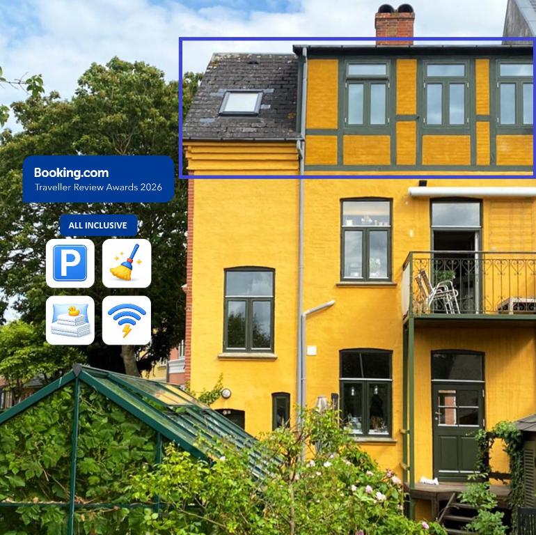 ein gelbes Gebäude mit einem Parkschild davor in der Unterkunft Townhouse with Garden and Free Parking in Odense