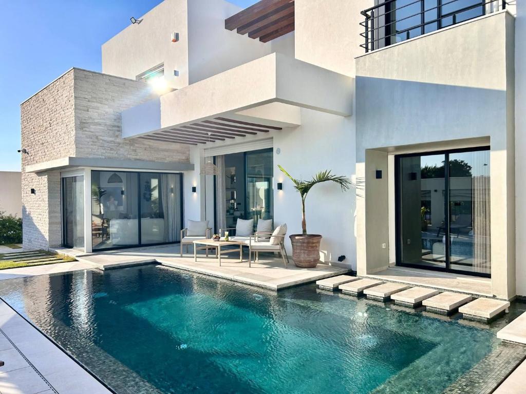 a house with a swimming pool in front of it at Villa Ulysse 4 Bedroom Private Pool in Hammamet