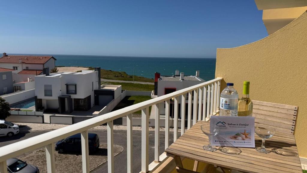 a table with a bottle of wine and glasses on a balcony at Sunset Hideaway Santa Cruz in Silveira