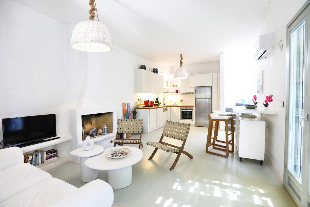 a white living room with a couch and a table at EMELIAS HOUSE SEA SIDE in Naxos Chora