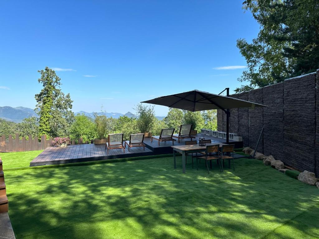 a patio with a table and chairs and an umbrella at Can Roura in Rocabruna