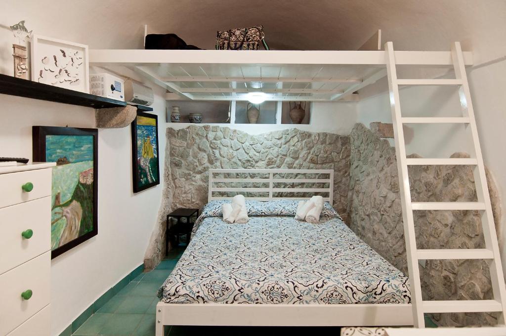 a bedroom with a bunk bed and a ladder at Casa Vacanza La Giosa in Sperlonga