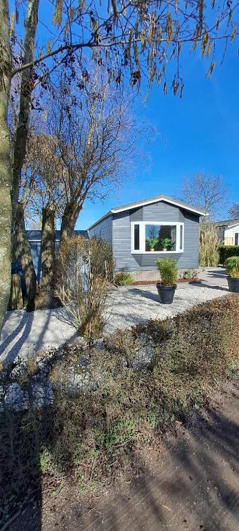 a small house with a window on a driveway at Comfortable Chalet in Berkhout