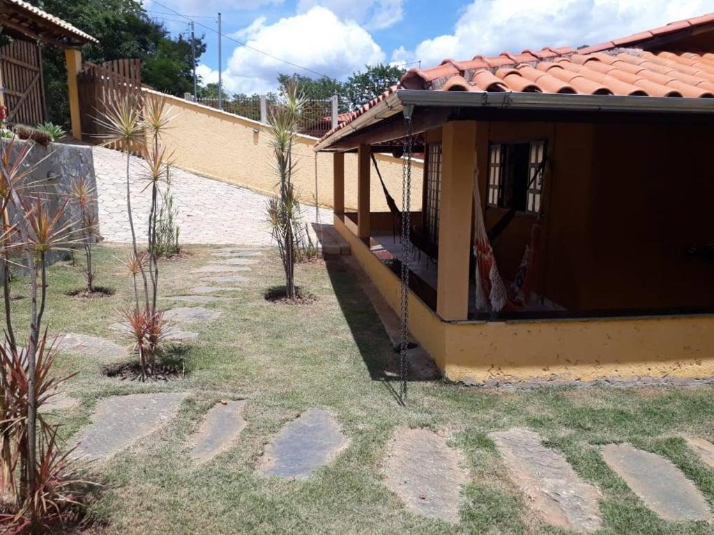 a house with a yard with palm trees at Sossego e Lazer na Serra do Cipó, piscina e Rio in Jaboticatubas