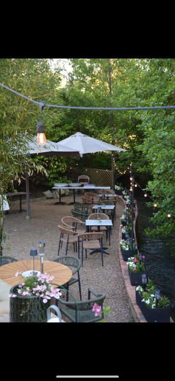 a group of tables and chairs with an umbrella at Le Molineuf in Orchaise