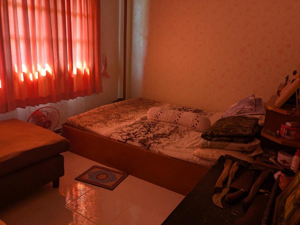 a small bedroom with a bed and a window at Chez ma mère Homestay in Ko Chetmun