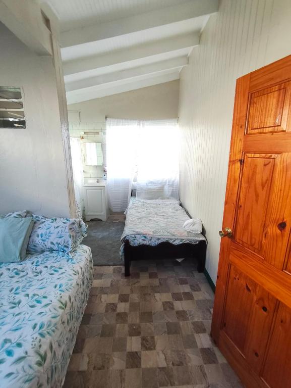 a small room with a bed and a window at Mage B&B 1 in Roseau