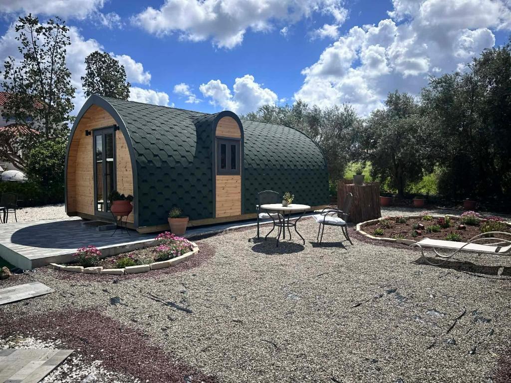 a small shed with a table and a patio at Casa Leandro glamping wooden tiny house in Lachi