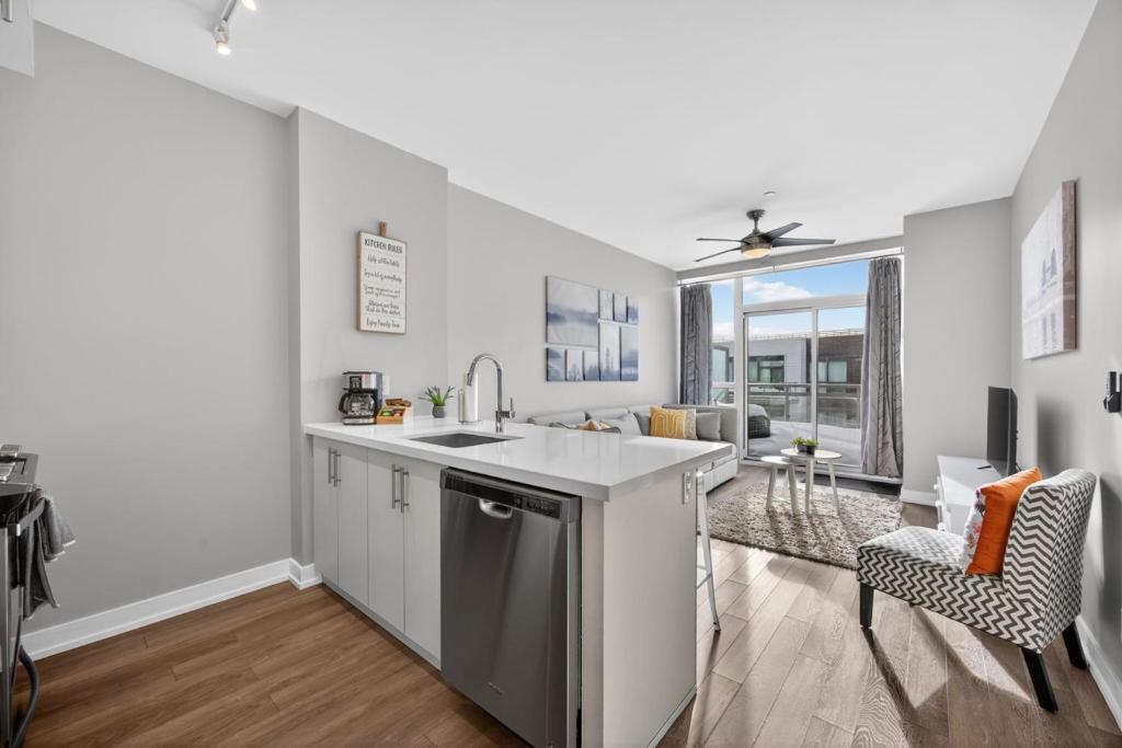 a kitchen with a sink and a living room at Lake Simcoe Stays - Friday Harbour's Official Rental Program - Scyamore Suite in Innisfil