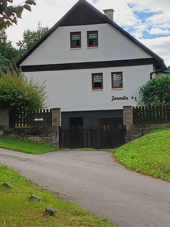 a white house with a fence in front of it at Jarmila in Tachov