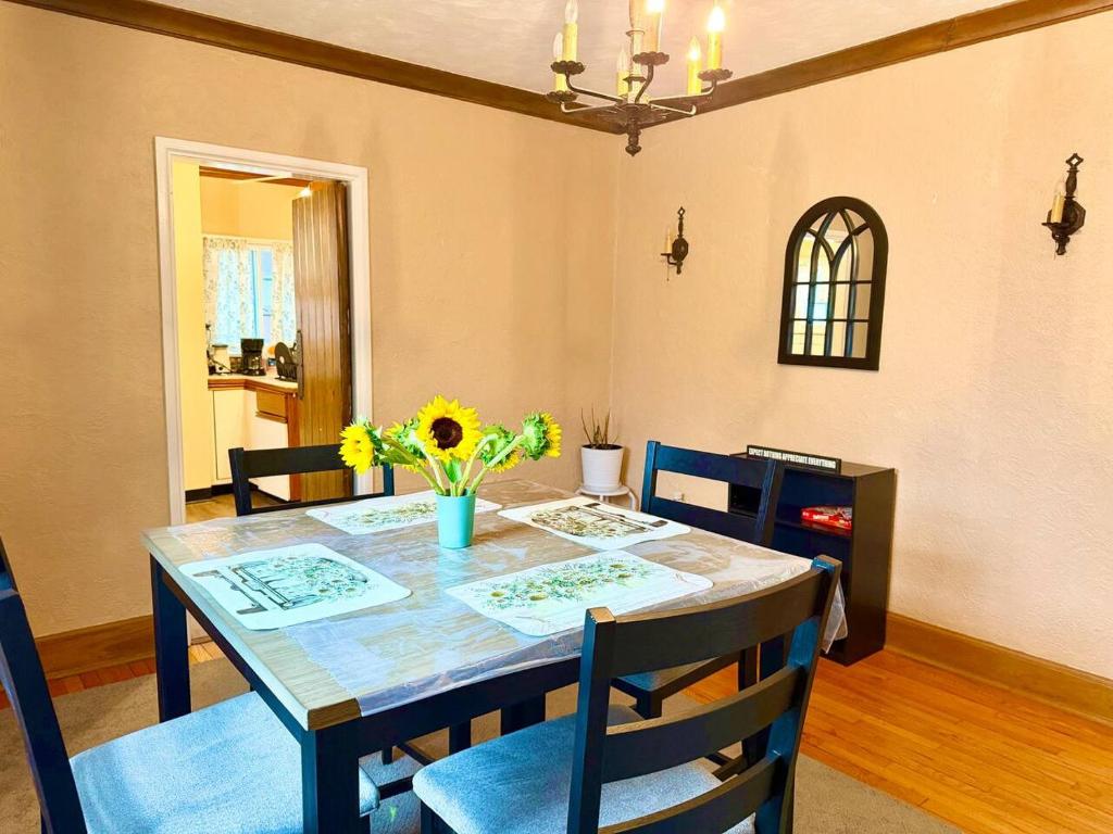 a dining room table with a vase of flowers on it at Queen Bed Shared Common Space Carrier Dome SU Hospitals in Syracuse