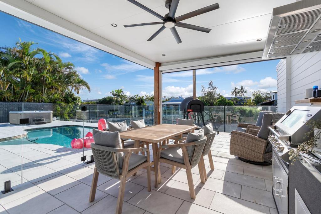 a patio with a table and chairs and a pool at Coastal Waterfront Broadbeach Waters in Gold Coast