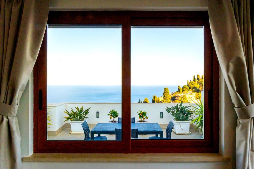 a window with a table and a view of the ocean at Tauromenion Guest House in Taormina