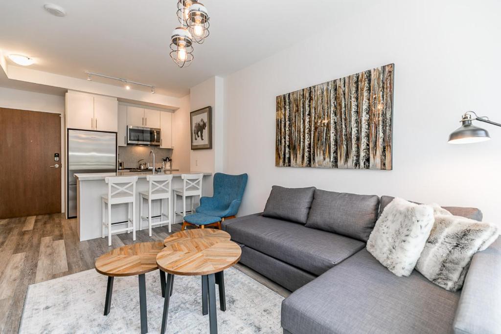 ein Wohnzimmer mit Sofa und Tisch in der Unterkunft Lake Simcoe Stays - Friday Harbour's Official Rental Program - Tamarack Suite in Innisfil