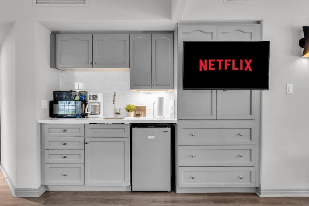 a kitchen with white cabinets and a sign that reads netflix at Lux Studio in Horseshoe Valley in Shanty Bay