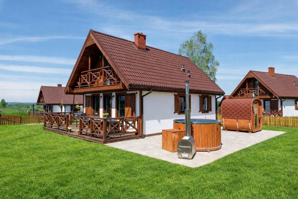 a house with a hot tub in the yard at Warmia Prestige in Woryty