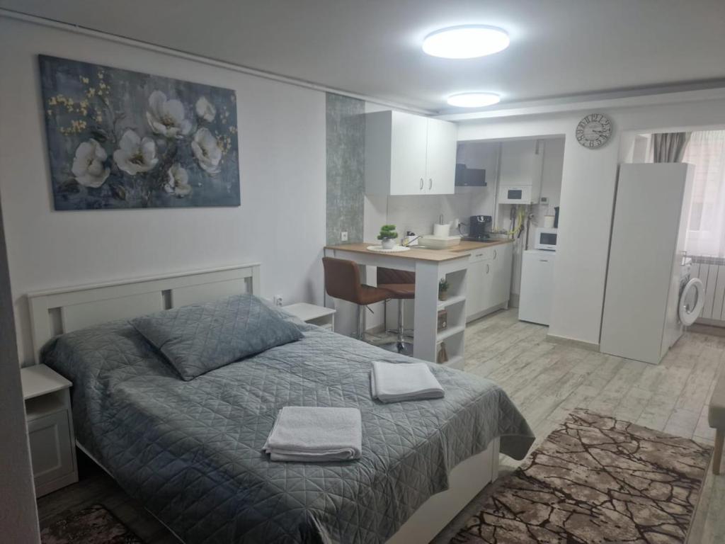 a bedroom with a bed with two towels on it at Central Studio in Târgu Secuiesc