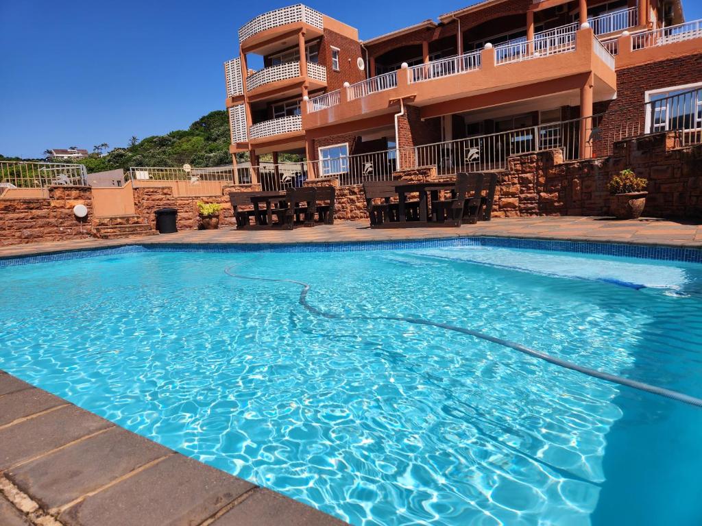 a swimming pool in front of a house at Golden Dawn Chalets in La Mercy