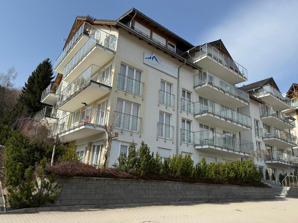a white building with balconies on the side of it at Apartament Rajka in Biała Woda
