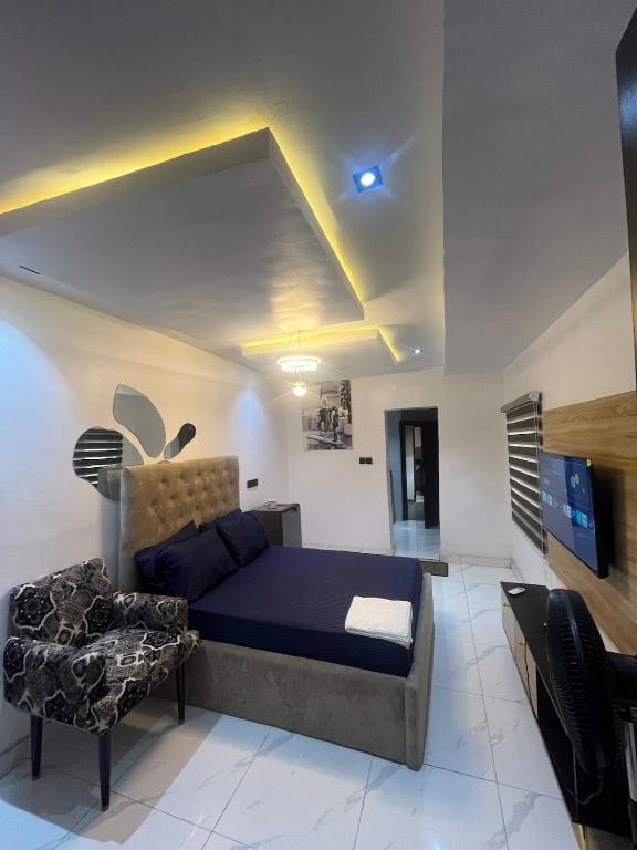 a bedroom with a bed and a couch and a tv at Studio Apartment with Rooftop & Pool Access in Lagos
