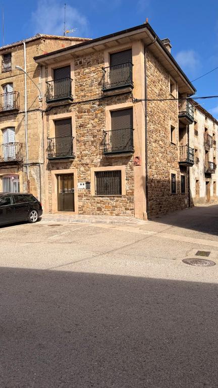 a brick building with a car parked in front of it at Casa Rural Piqueras in Almarza