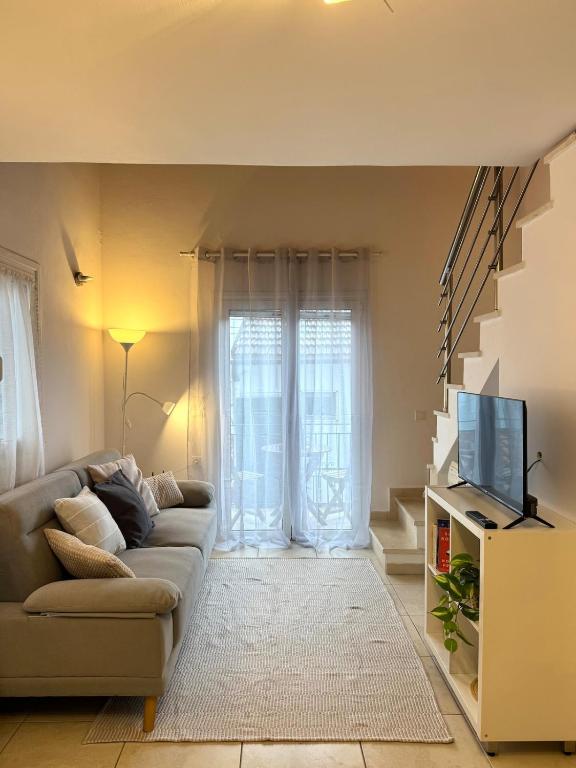 a living room with a couch and a tv at Ntina Apartment - Loggos, Paxos in Longós