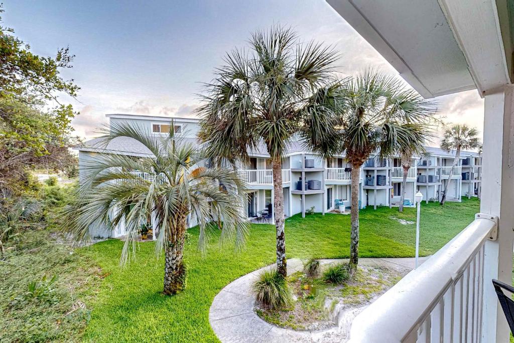 a balcony view of a building with palm trees at Sand Dollar E201 in Pensacola Beach