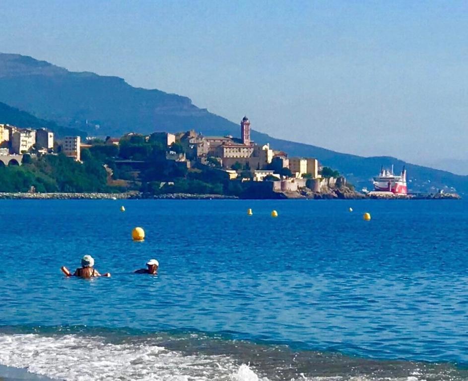 two people swimming in a large body of water at Maison in Bastia