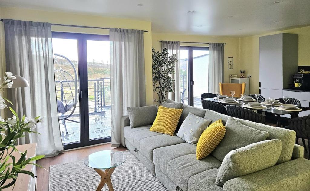 a living room with a couch and a dining room at Luxus-Penthouse mit Panorama-View in Netphen