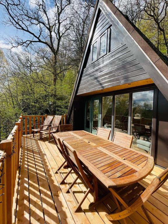 a wooden deck with chairs and a wooden table at La Cachette De Durbuy - Chalet 203 in Durbuy
